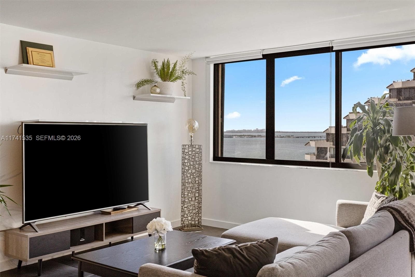 Step into this bright and open living space, where large windows offer stunning views of Biscayne Bay. Desirable split floor plan, ensuring privacy and functionality. The sleek, modern finishes include large format tile flooring, a neutral color palette, and minimalist floating shelves for a touch of sophistication. Relax while enjoying the picturesque scenery or step onto the balcony for a closer look at the serene waterfront.